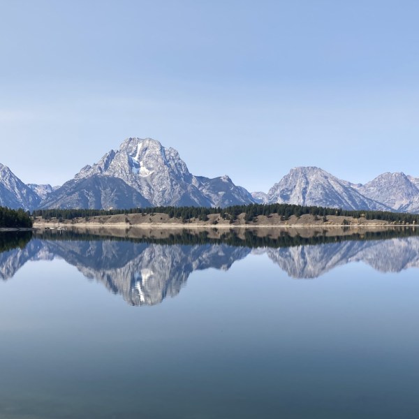 a bridge over a body of water with a mountain in the background