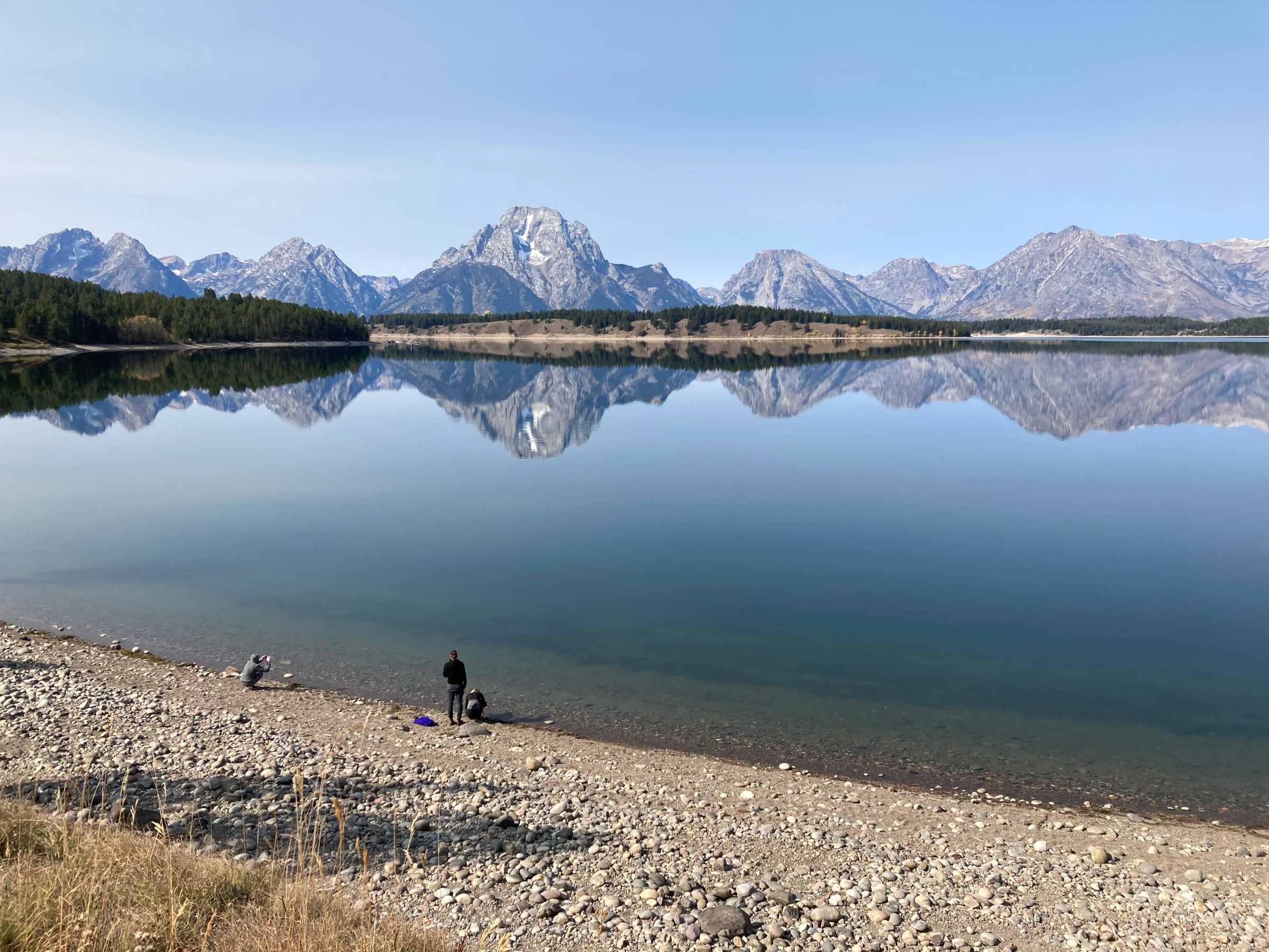 a man standing next to a body of water