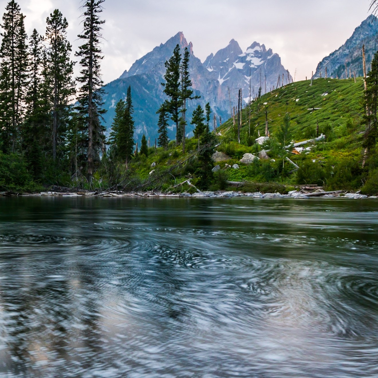 a pond with Tetons in the background