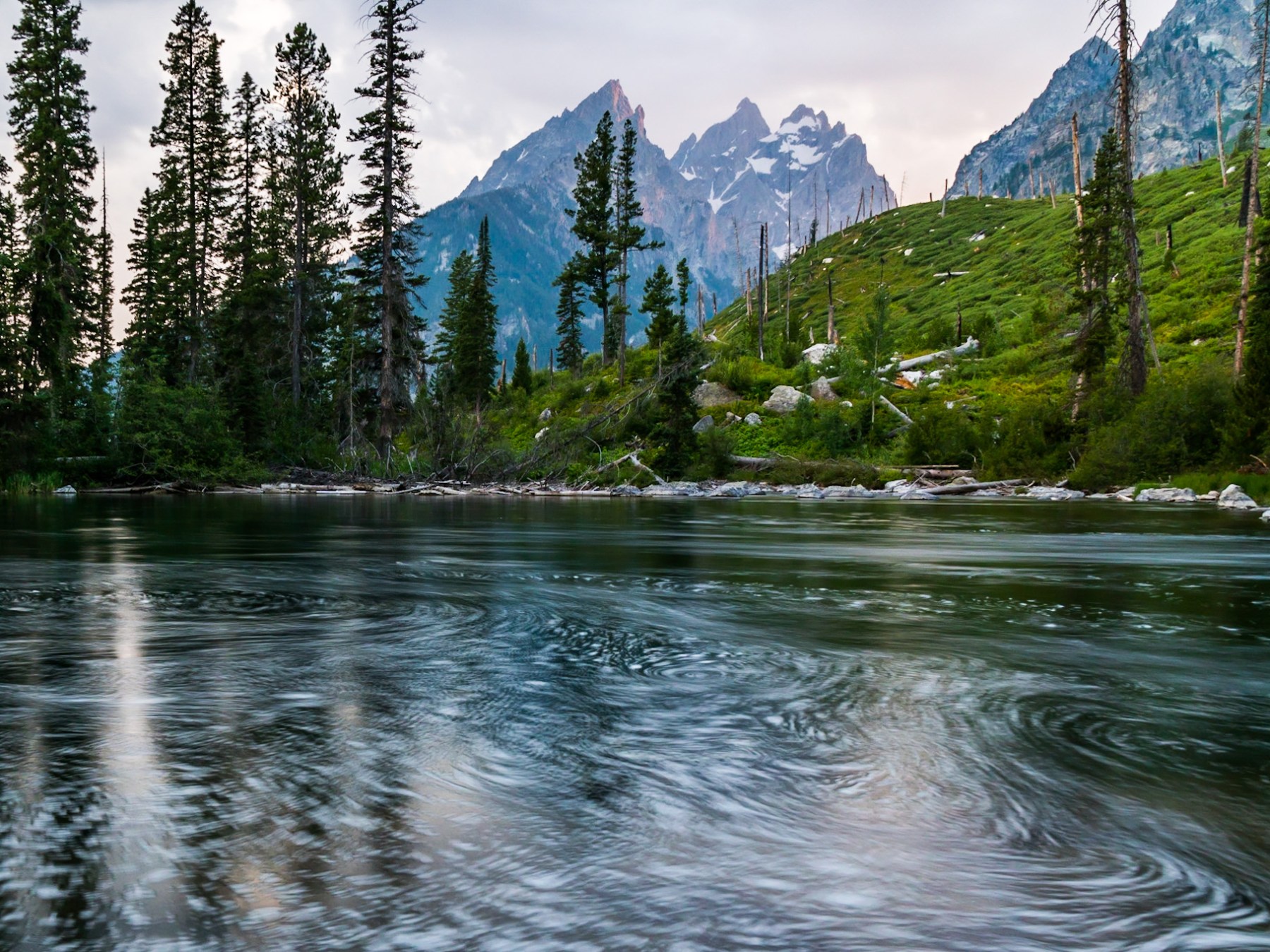 a pond with Tetons in the background