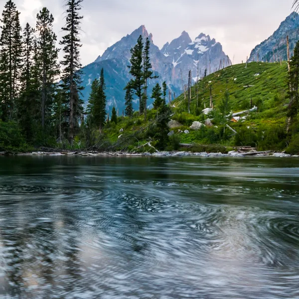 a pond with Tetons in the background