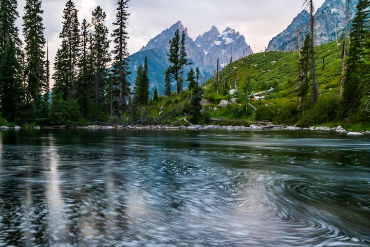 a pond with Tetons in the background