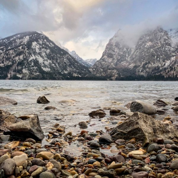 a rocky island in the middle of a snow covered mountain
