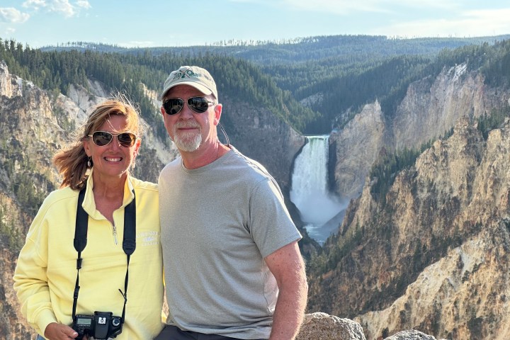 Couple standing in front of the Lower Yellowstone Falls