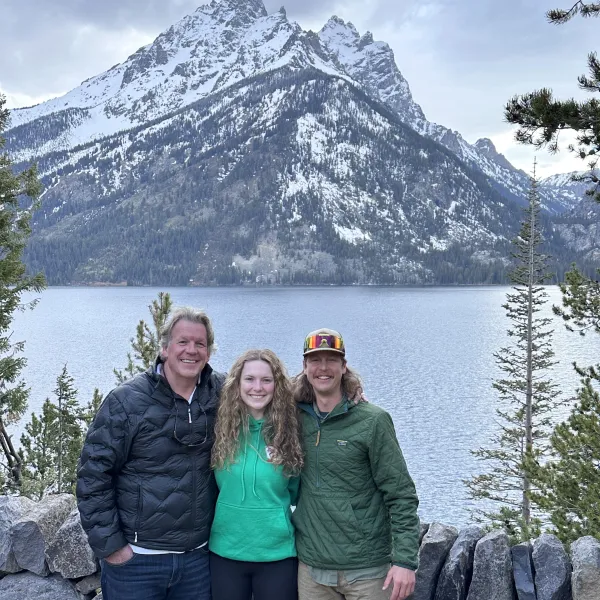 Father daughter guests on tour posing at Jenny Lake Overlook with guide Brett